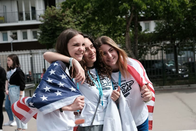 Des élèves s’enlacent et partagent un moment d’amitié en high school à l’étranger, entre échange culturel, nouvelles relations et esprit international.