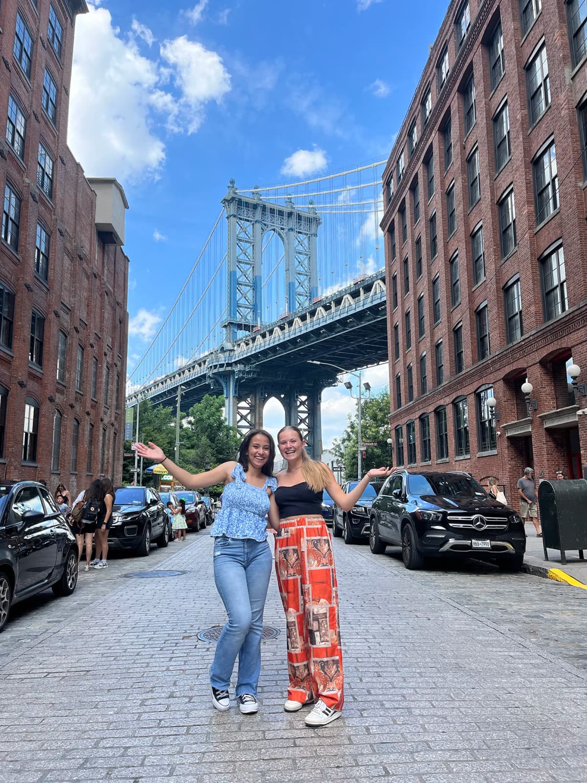 Étudiantes à DUMBO pendant des cours de langue à New York, avec le Manhattan Bridge en arrière-plan.